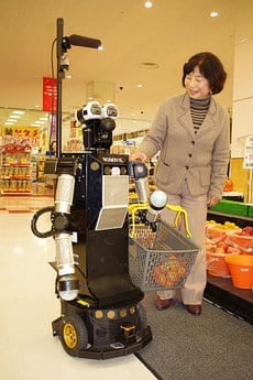 Robovie-II Helping an Elderly Woman With Her Grocery Shopping.