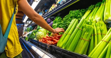 Customer picking produce at grocery store