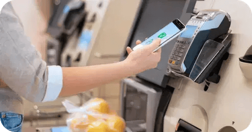 Woman scanning phone on self checkout machine