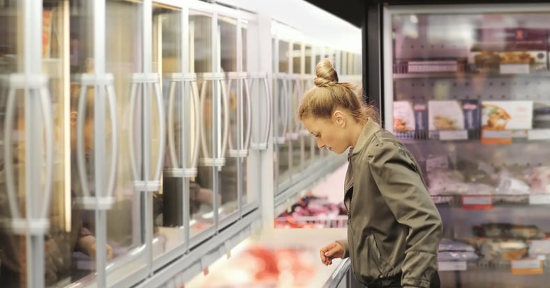 woman shopping the freezer aisle